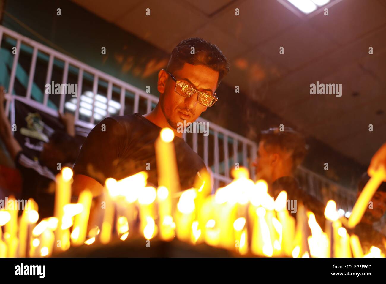 Karbala, Iraq. 19th Aug, 2021. A Shiite Muslim man lights candles at the Imam Abbas shrine in Iraq's holy city of Karbala on Ashura Day on the 10th of Muharram, the first month of the Islamic calendar. Muharram is considered a month of mourning and remembrance for Shiite Muslims around the world, in which they commemorate the martyrdom of the grandson of the Islamic prophet Mohammad, Husayn ibn Ali, who was killed in the 7th century Battle of Karbala. Credit: Ameer Al Mohammedaw/dpa/Alamy Live News Stock Photo