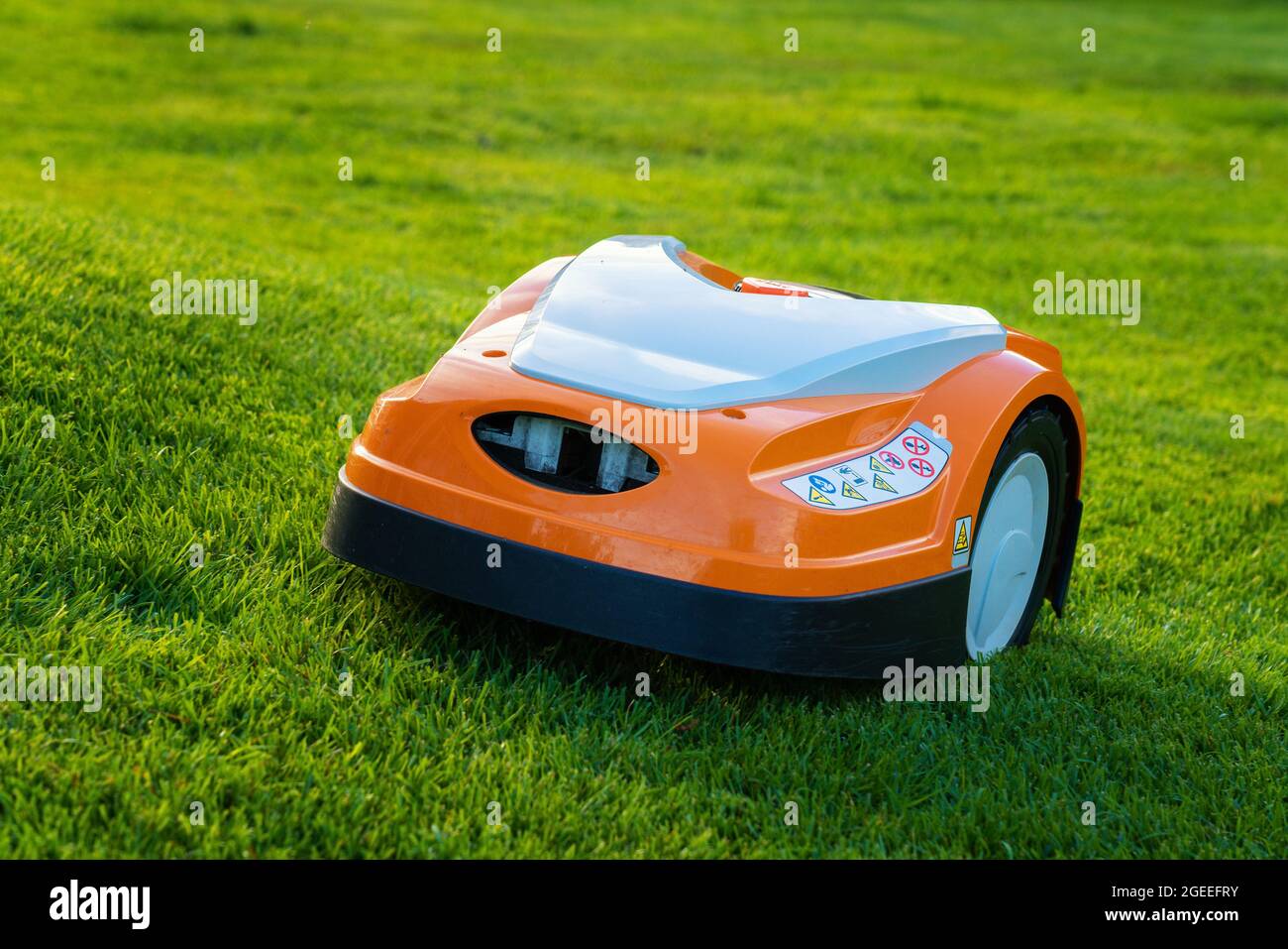 Automatic lawn robot mower moves on the grass slope, lawn. Close up