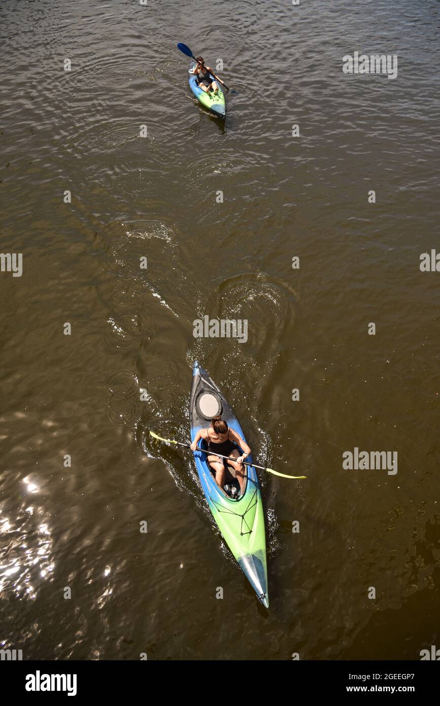 Aerial view women paddling kayaks for exercise and enjoyment of the outdoors on brown-colored waters of Milwaukee River in downtown Milwaukee, WI, USA Stock Photo