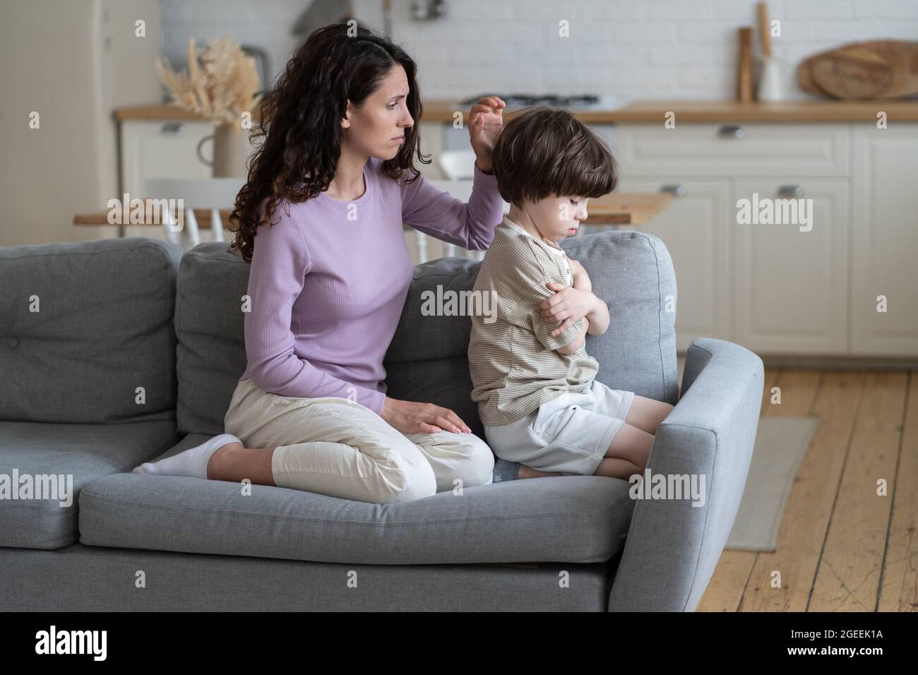 Excusing mother try to make peace with stubborn offended boy kid frowning and ignoring caring mom Stock Photo