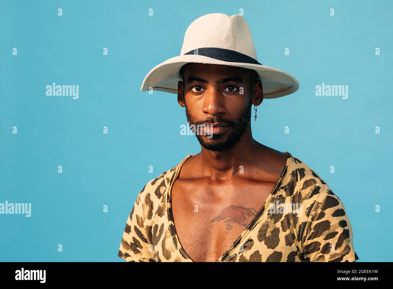 Portrait of African American guy wearing straw hat and looking straight