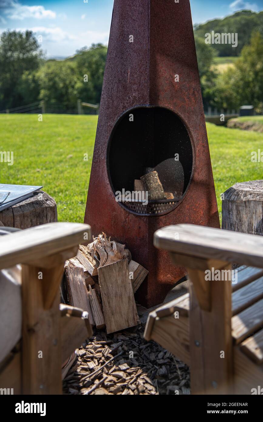 ood butning area with little stove and two wooden chairs, Kent, UK. Stock Photo