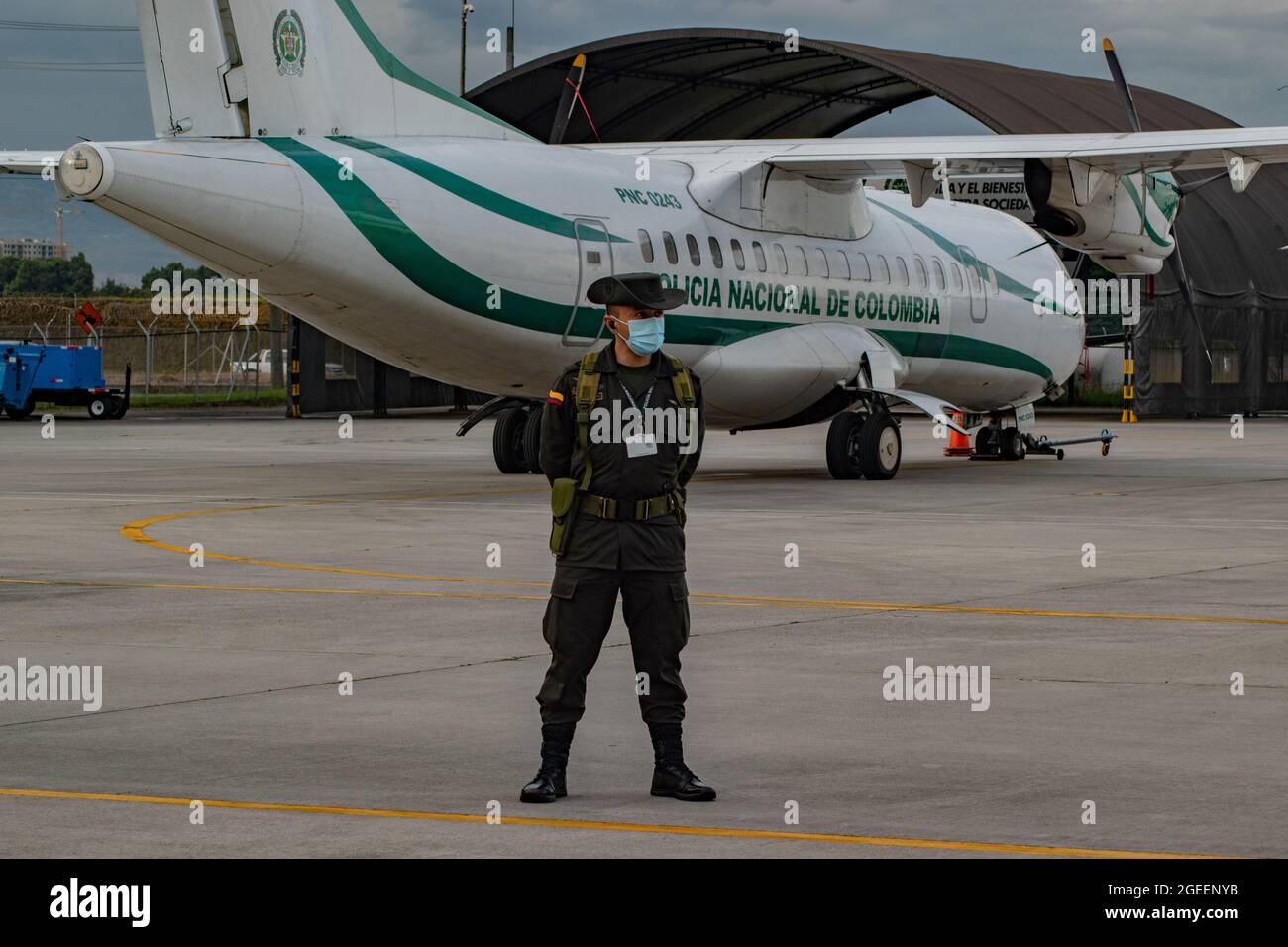 Bogota, Colombia. 19th Aug, 2021. A anti-narcotics police officer stands in front of a Colombian police plane as Yamit picon Rodriguez alias 'CHONCHA' Henry Trigos Celon alias 'HENRY' both from the ELN Guerrilla and Alexander Montoya Usuga alias 'El Flaco' from the Gulf Clan 'Clan del Golfo' are scorted by Interpol Police and Colombia's police prior to their extradition to the United States, in the CATAM army base in Bogota, Colombia on August 19, 2021. Credit: Long Visual Press/Alamy Live News Stock Photo