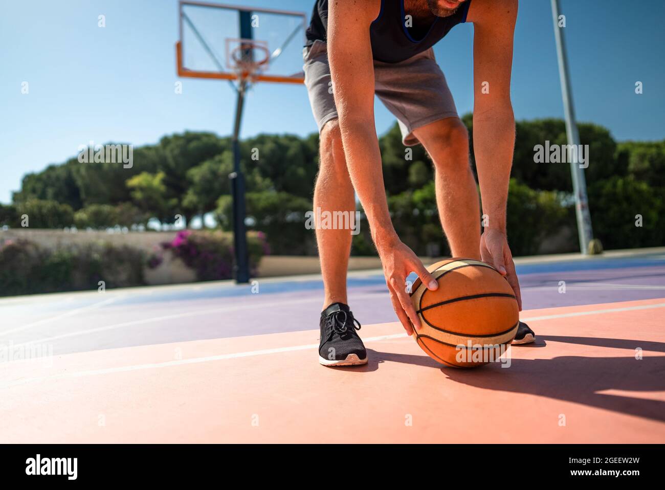 basketball player on the playground picks up the ball from the ground