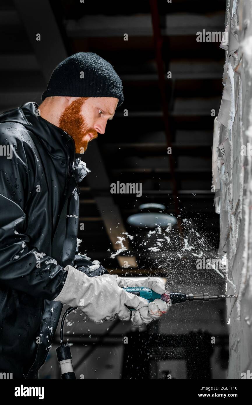 Professional ice carver sculpting block of ice Stock Photo