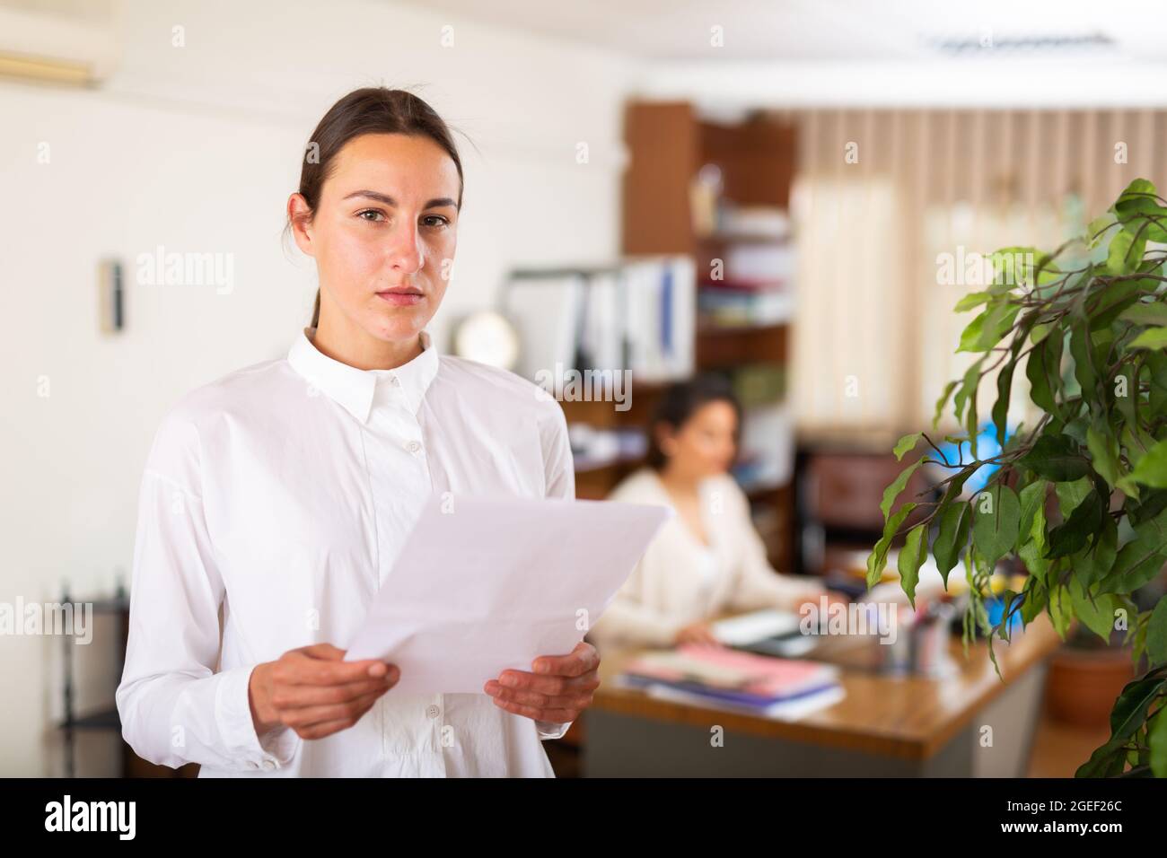 Unhappy female office employee after reprimand from angry chief Stock Photo