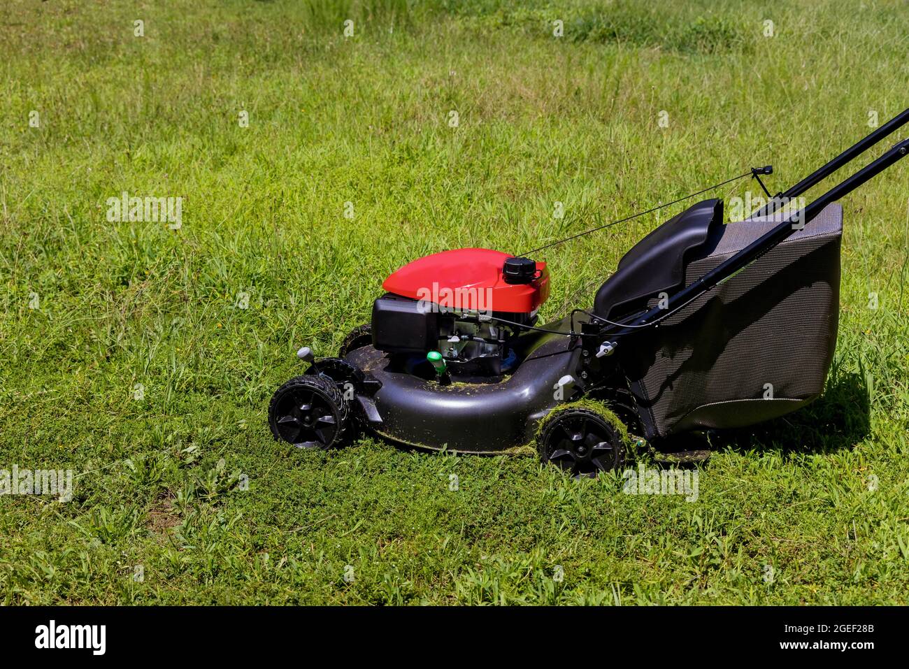 Ride-on lawnmower utility worker in lawn mower gardener cutting the grass Stock Photo