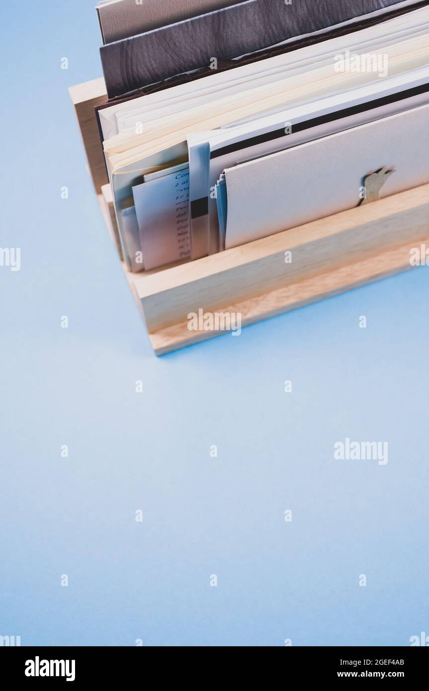 Vertical shot of a wooden box filled with papers on a blue surface Stock Photo