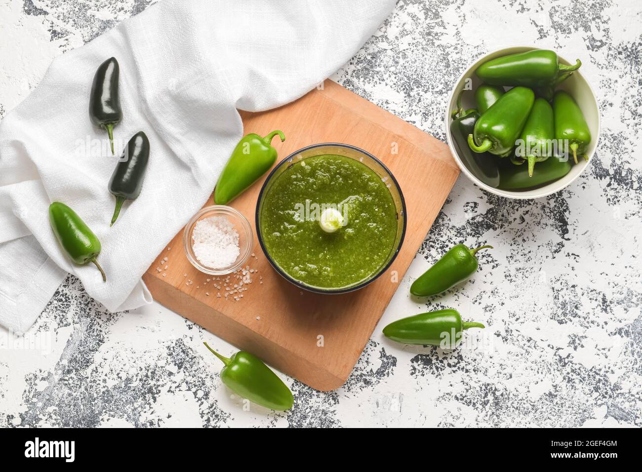 Blender with Tomatillo Salsa Verde sauce and jalapeno pepper on grunge background Stock Photo