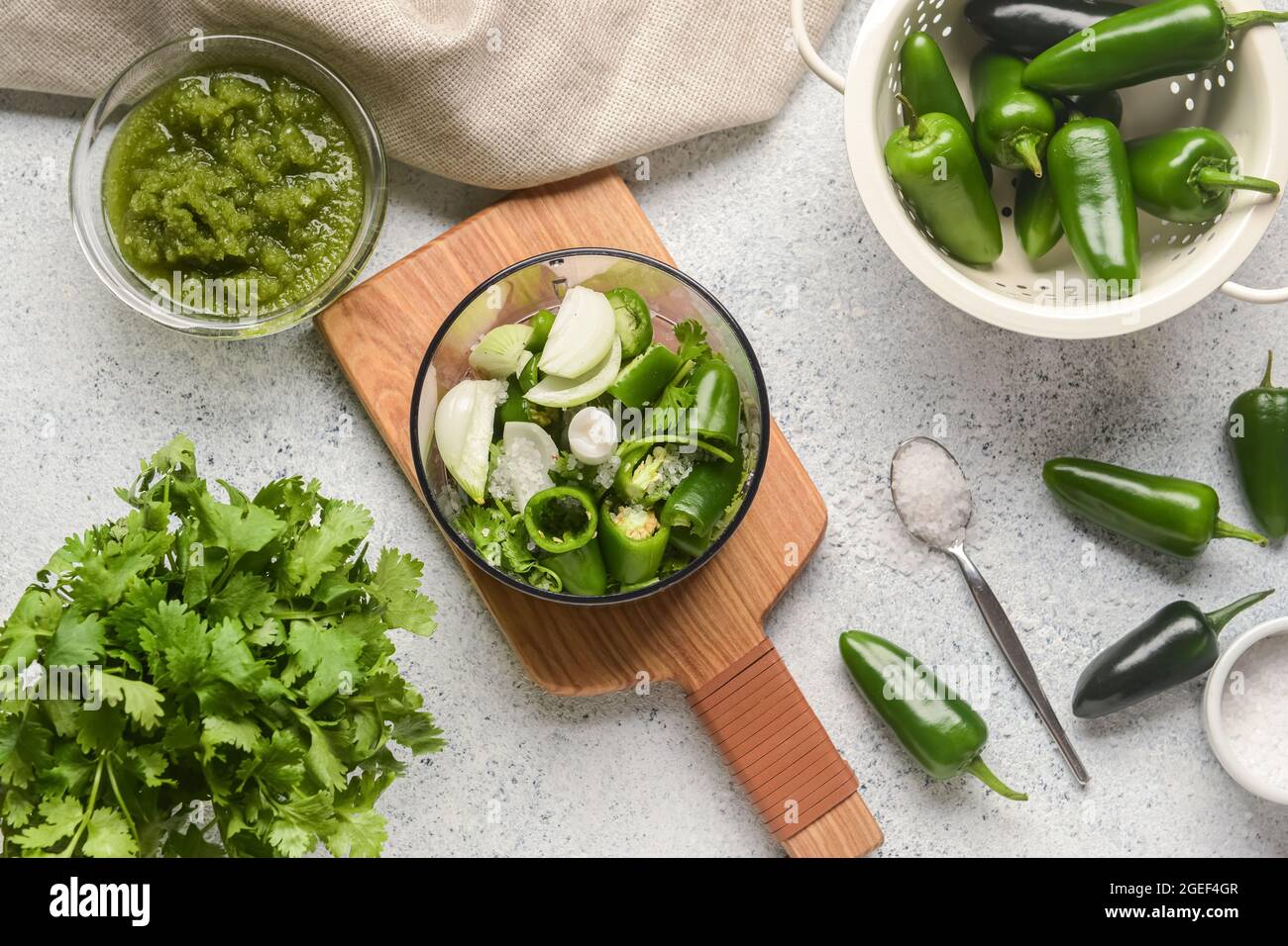 Blender with ingredients for Tomatillo Salsa Verde sauce on light background Stock Photo