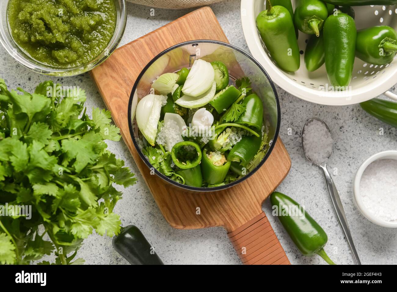 Blender with ingredients for Tomatillo Salsa Verde sauce on light background Stock Photo