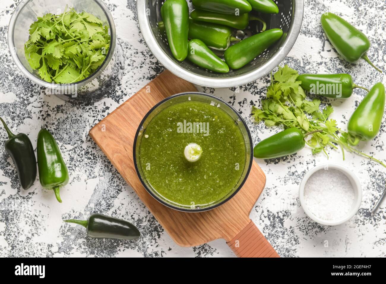 Blender with Tomatillo Salsa Verde sauce and ingredients on grunge background Stock Photo