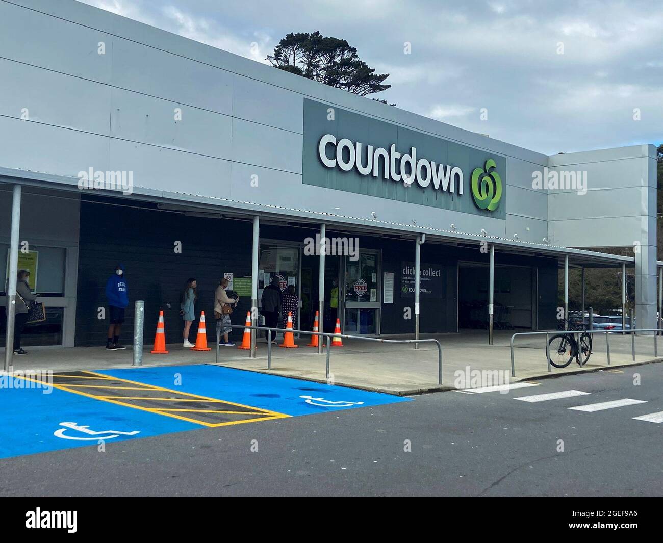 People stand in line outside a grocery store as a lockdown to curb the spread of cases of the coronavirus disease (COVID-19) remains in place in Wellington, New Zealand, August 20, 2021.  REUTERS/Praveen Menon Stock Photo