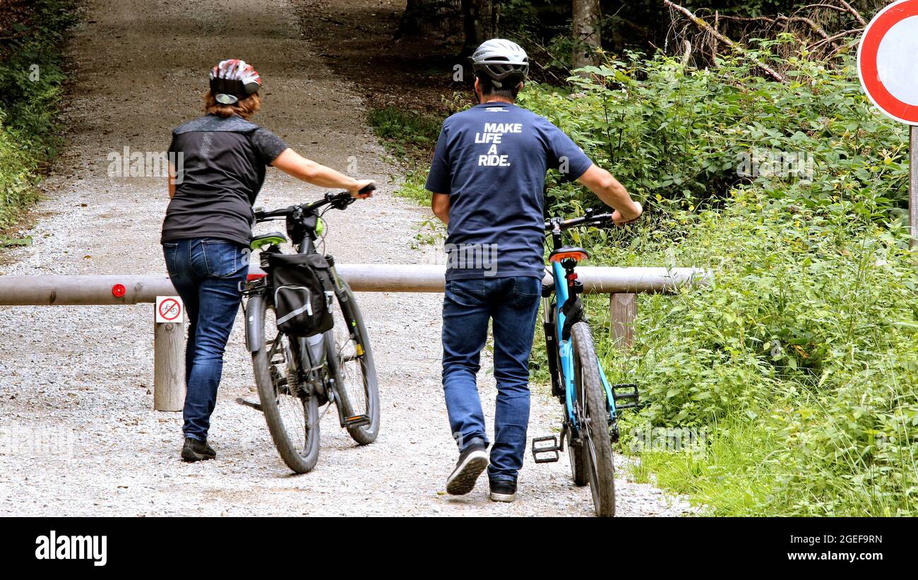 BAYERN, GERMANY - Aug 15, 2021: two people with bike on the way in the forest Stock Photo