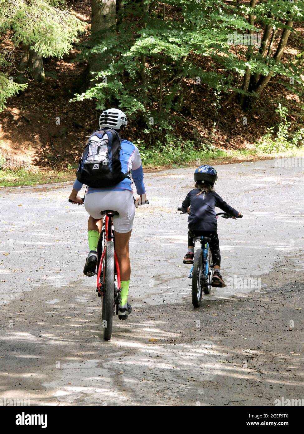 BAYERN, GERMANY - Aug 15, 2021: mother and child with bike on the way in the forest Stock Photo