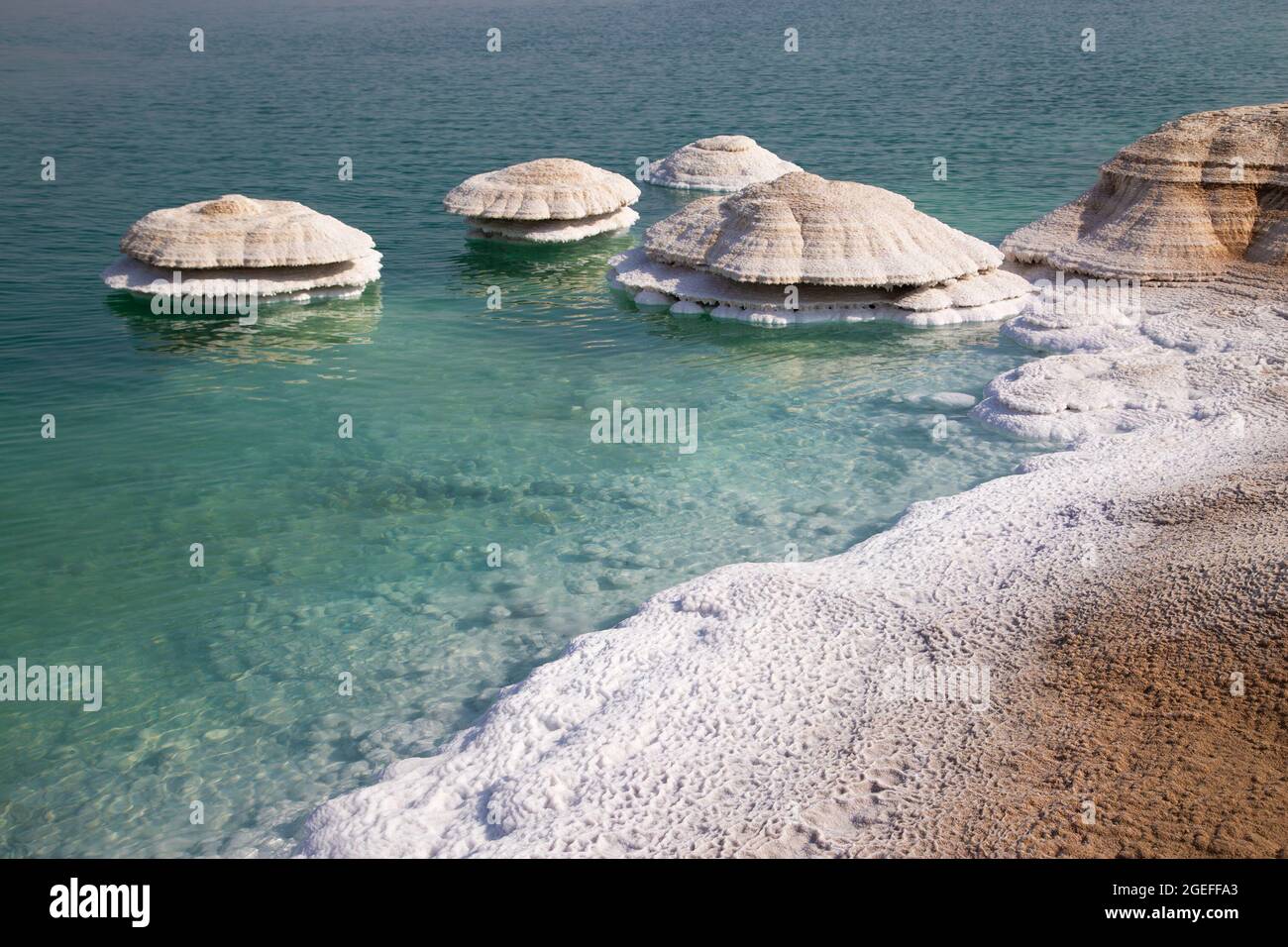 Salt chimneys on the Dead Sea shore form where fresh water flows into the saline lake water and are exposed as the water level drops. Stock Photo