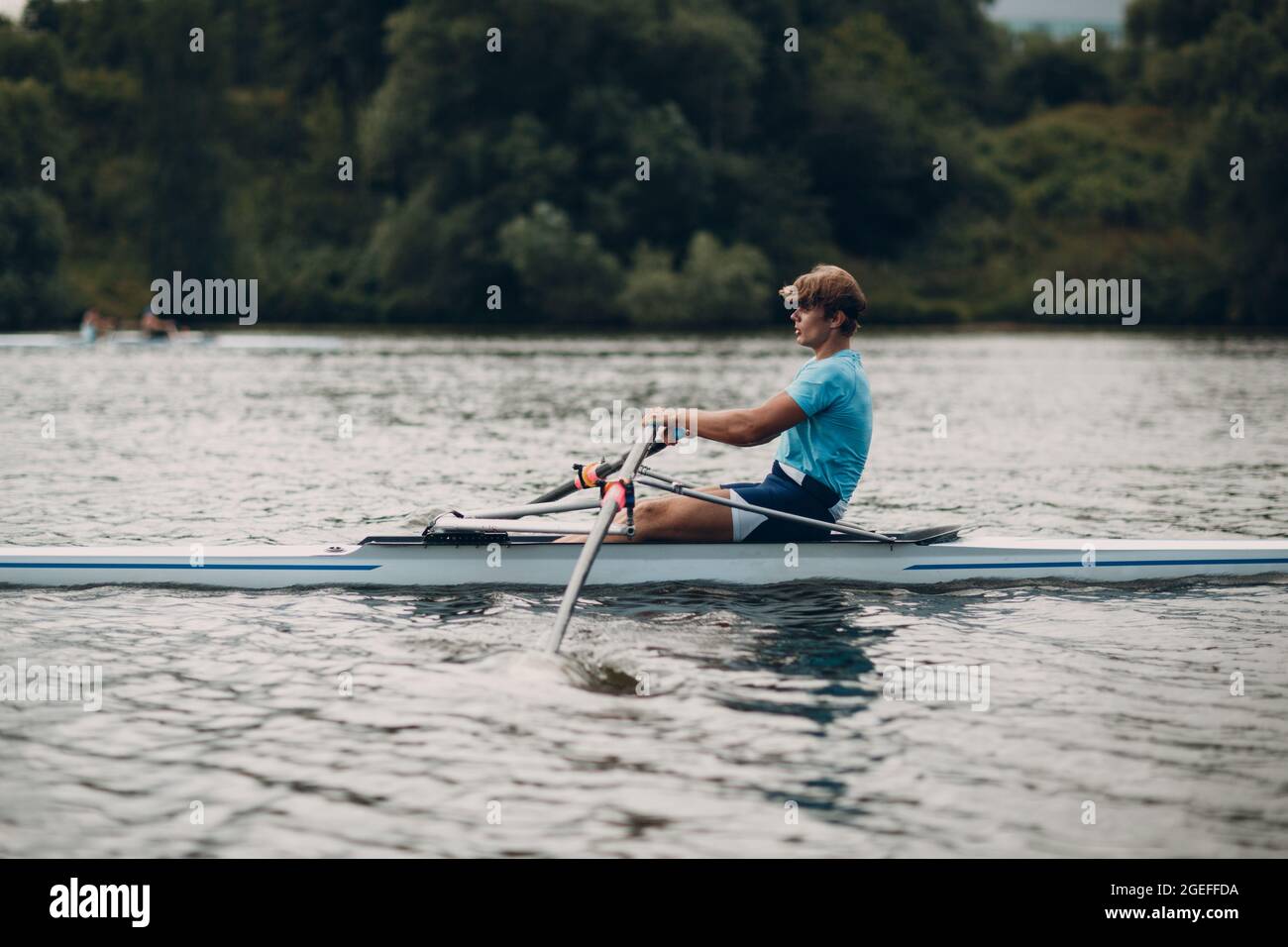 Sportsman oarsman single scull man rower rowing on boat oars side view  Stock Photo - Alamy
