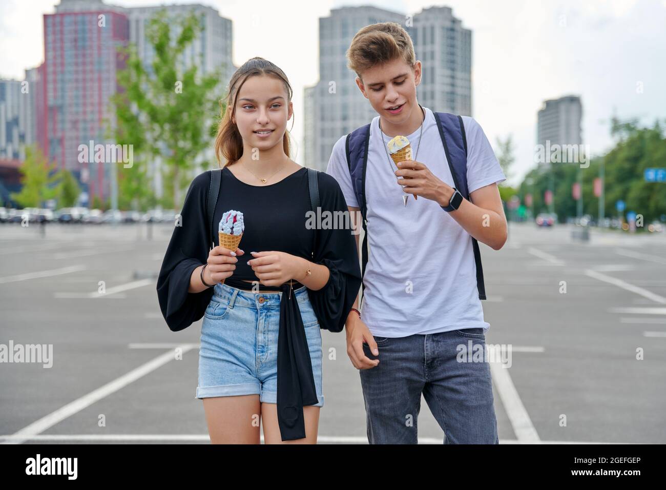 Happy talking couple of teenagers walking together in the city Stock Photo