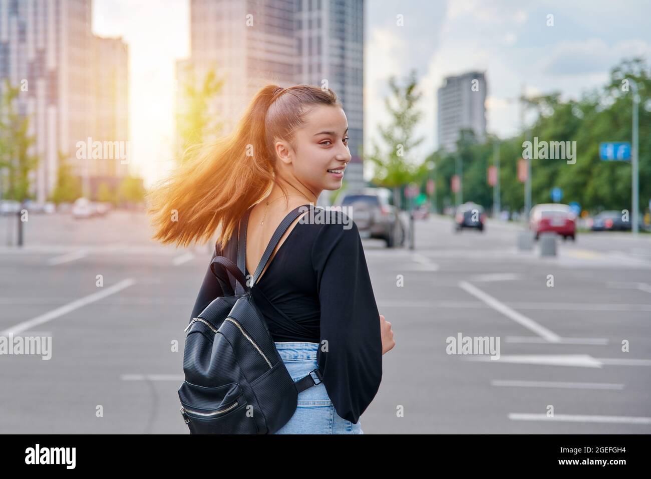 Fashionable beautiful smiling teenage girl in shorts with backpack Stock Photo
