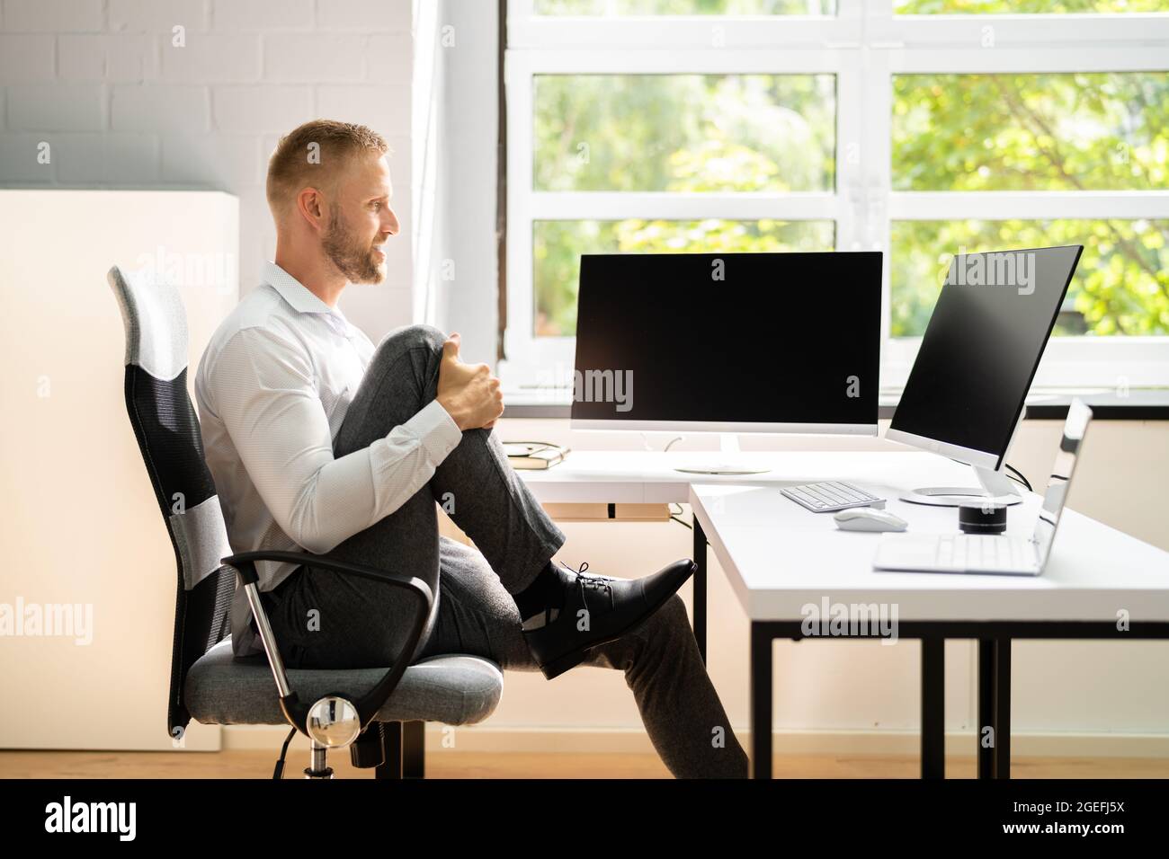 Yoga Workout In Office Behind Business Computer. Gymnastics And Leg ...