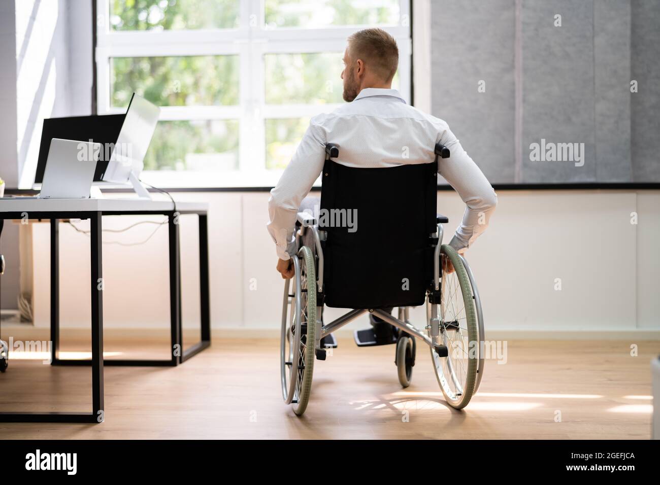 Man In Wheel Chair. Corporate Injury And Physical Access Stock Photo