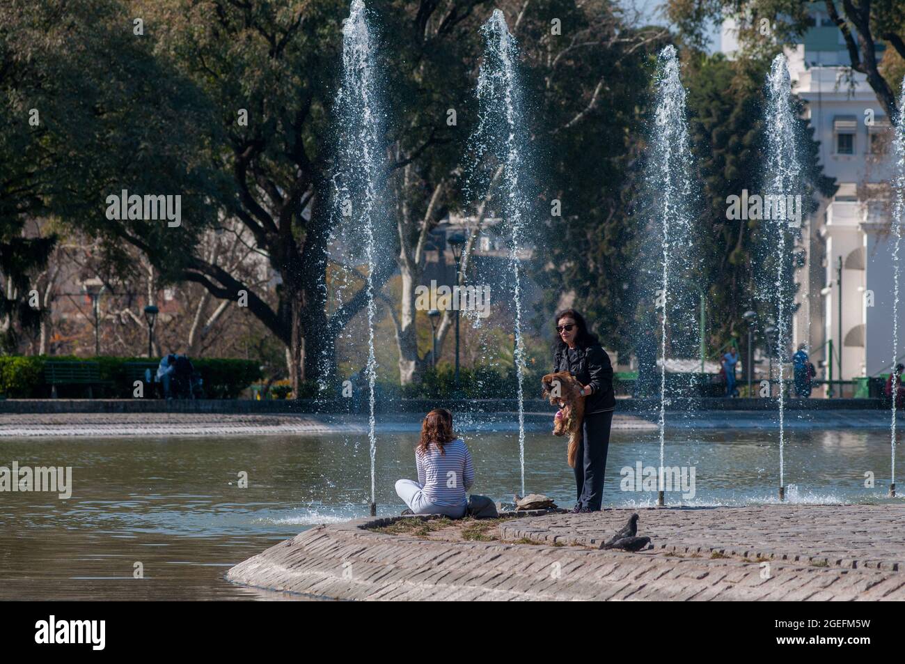 BUENOS AIRES, ARGENTINA - Aug 21, 2013: A pair of females talking near an artificial lake in Parque Centenario, Buenos Aires, Argentina Stock Photo