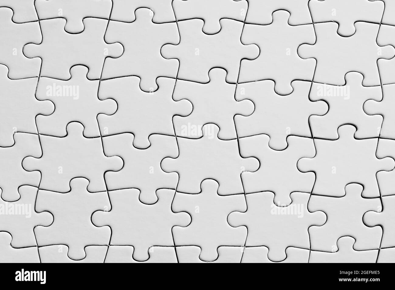 Empty white jigsaw puzzle background. Overhead view with copy space. Stock Photo