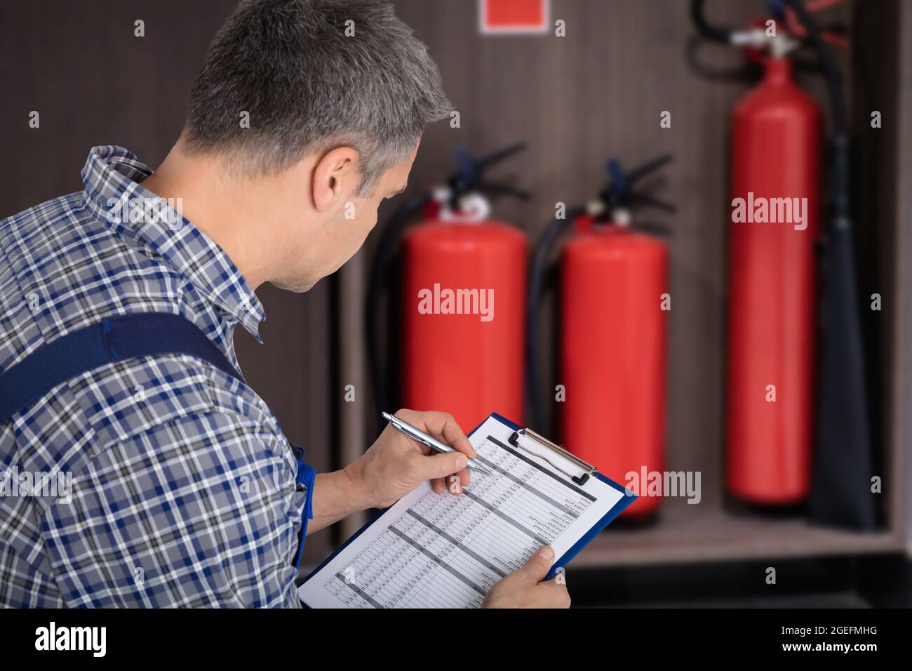 Checking Fire Extinguisher. Safety And Emergency Prevention Stock Photo