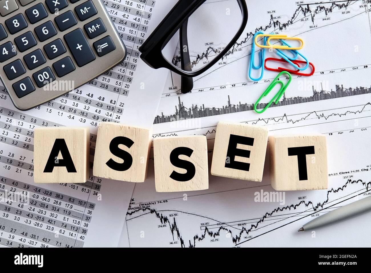 The word asset on wooden cubes with office desktop. Asset management, planning analysis or calculation concept. Stock Photo