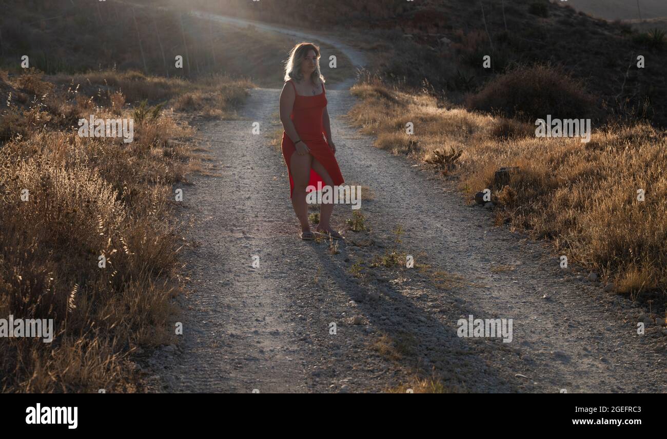 Girl in red dress in field Stock Photo - Alamy