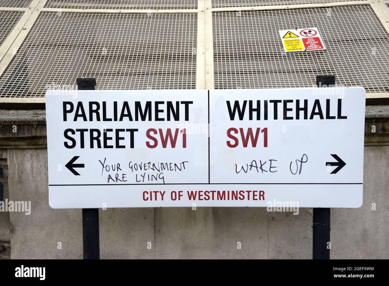 London, England, UK. Street sign: Parliament Street / Whitehall with political graffiti (July 2021) Stock Photo