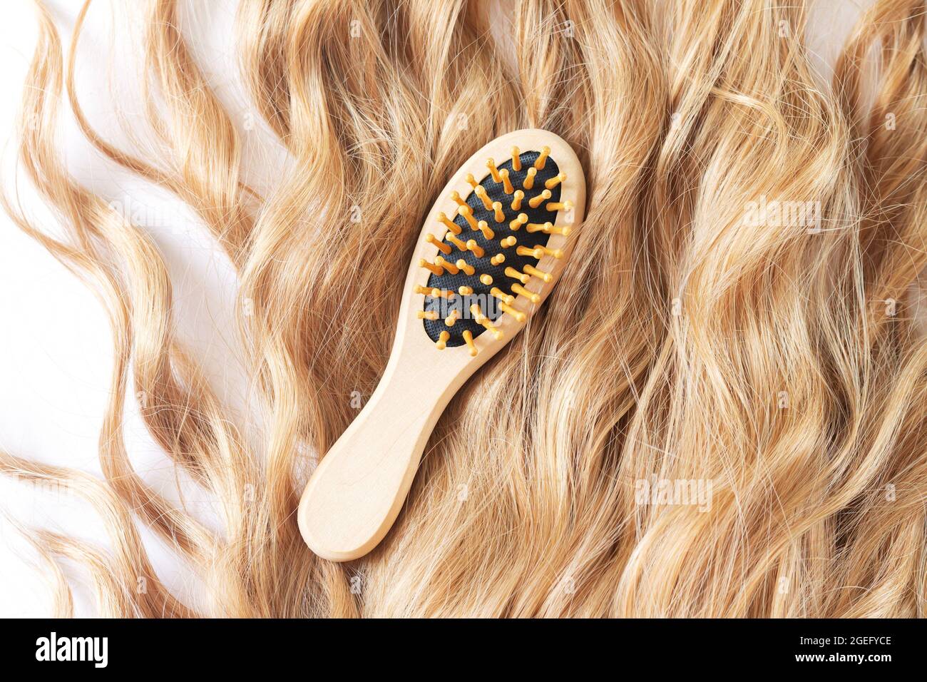 Beautiful blond female wavy hair and bamboo comb brush top view Stock Photo Alamy