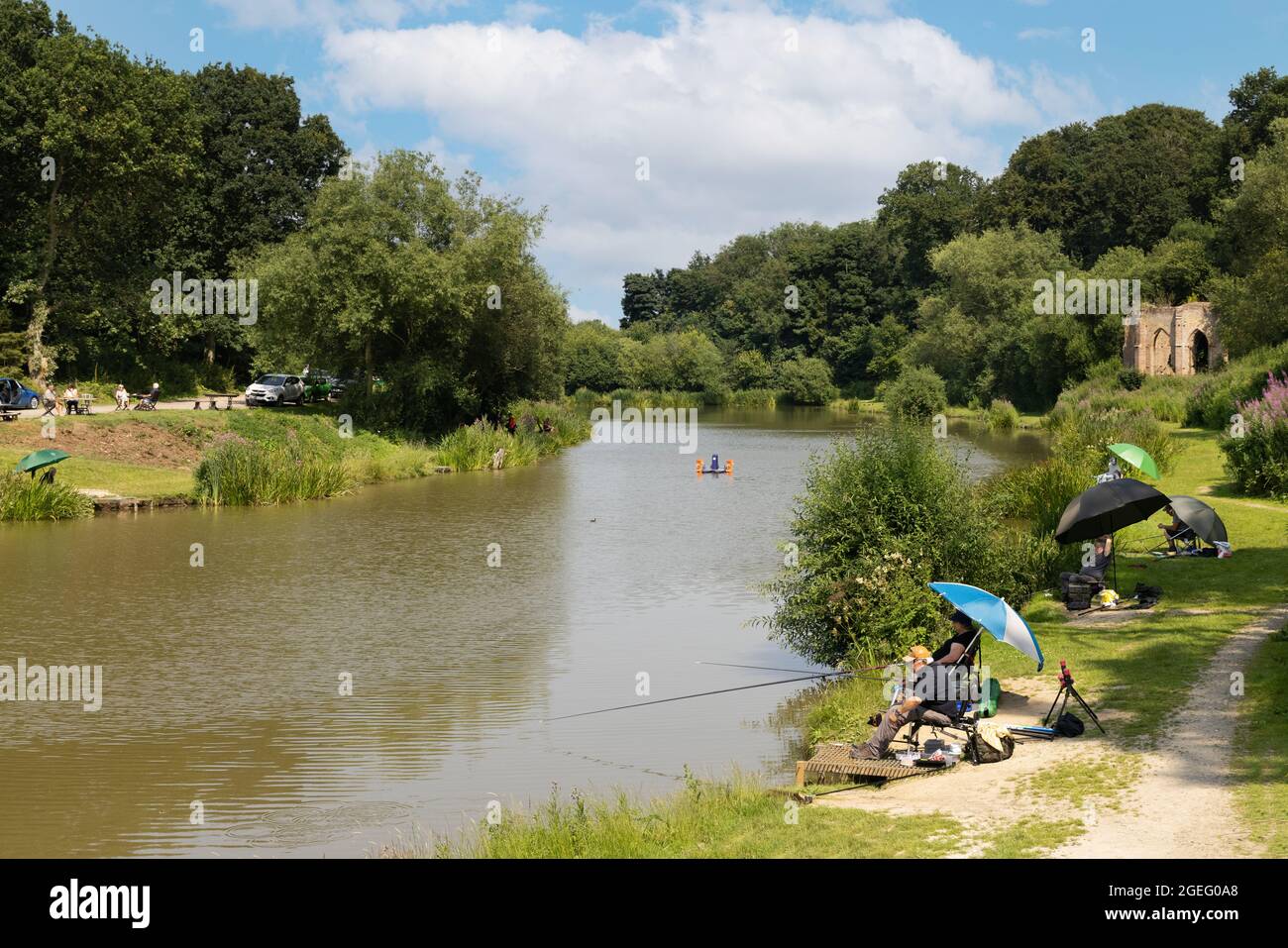 Angling UK; people fishing in Folly Lake, Risby Folly in the background, Risby, near Beverley, East Yorkshire UK on a sunny day in summer, July Stock Photo