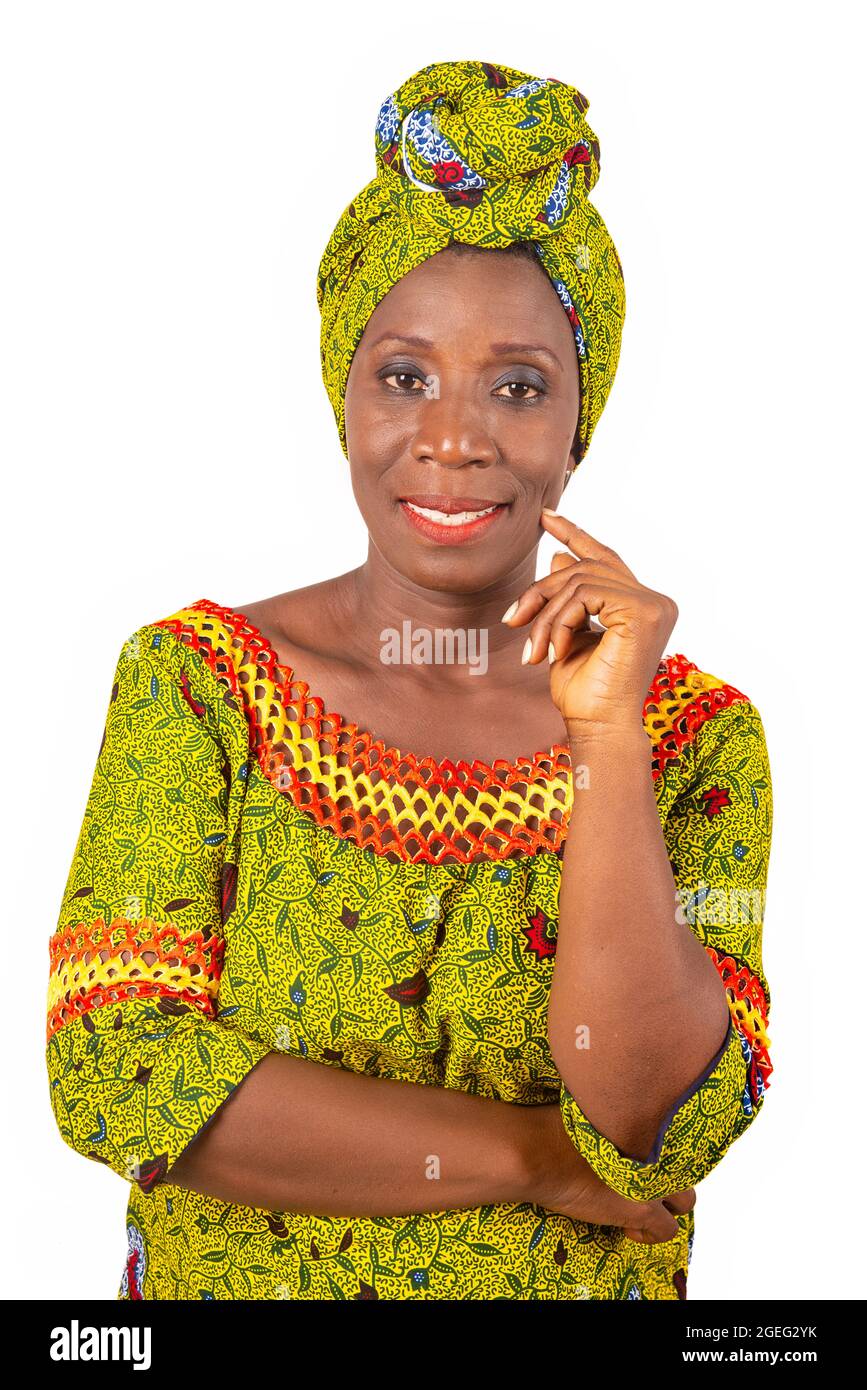 beautiful African adult woman wearing a loincloth and a green scarf is smiling with her arm crossed and her hand on her chin Stock Photo