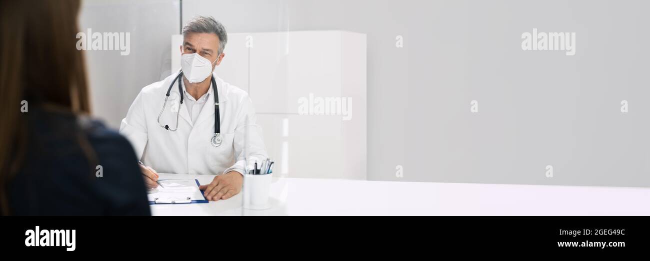 Doctor Consultant With Mask And Sneeze Guard Talking To Pregnant Woman Stock Photo