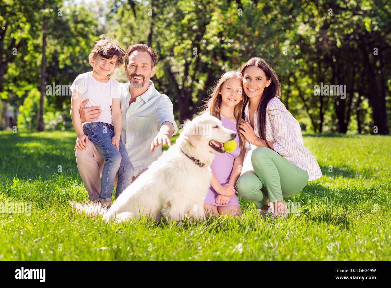 Photo of sweet friendly family dressed casual outfit sitting green