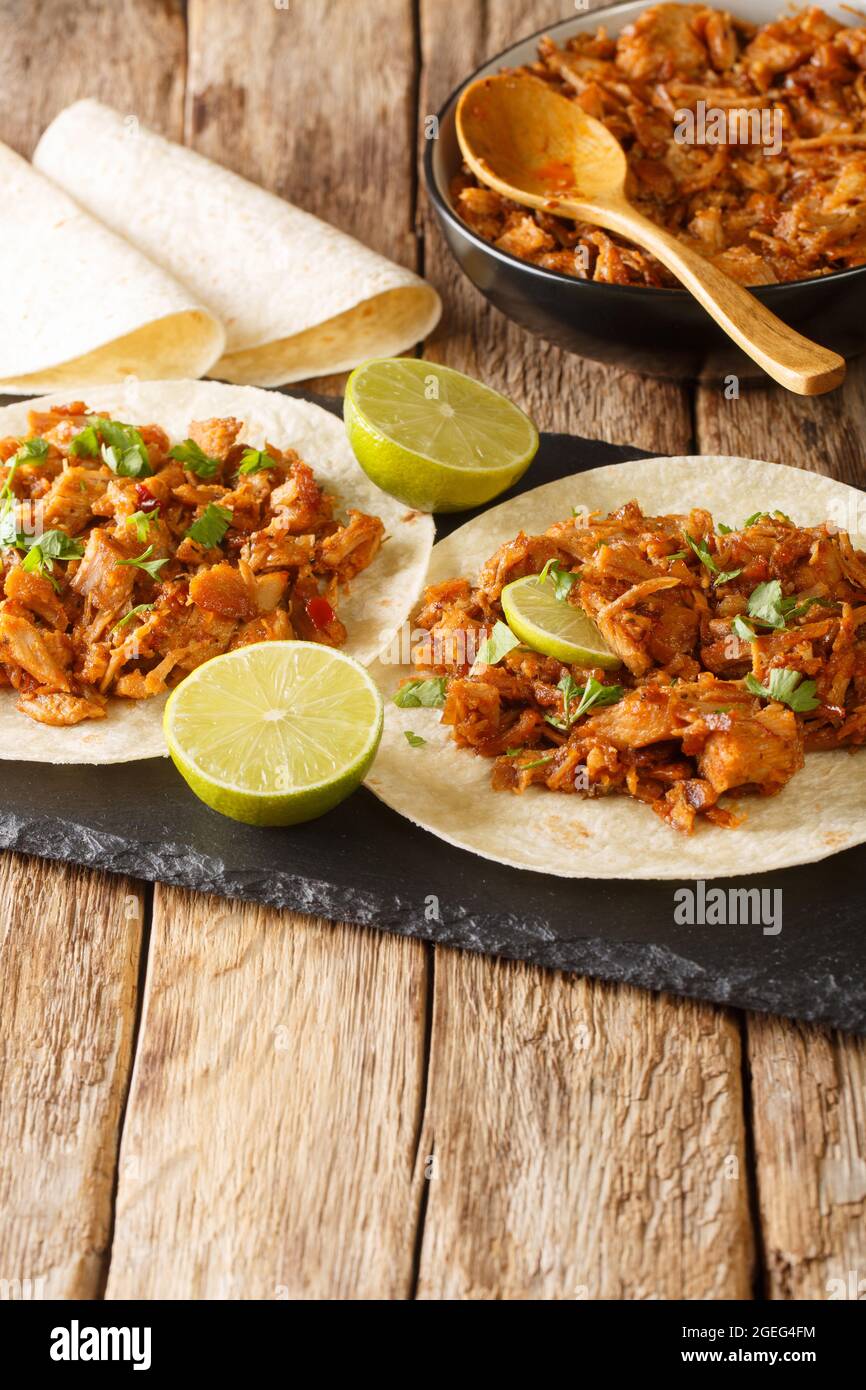 Sinaloan Pork in Chile Sauce Chilorio with tortilla and lime closeup in the slate board on the table. Vertical Stock Photo