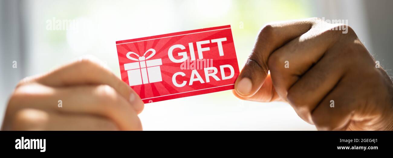 Shopping Gift Card Or Voucher. Hand Giving Incentive Stock Photo