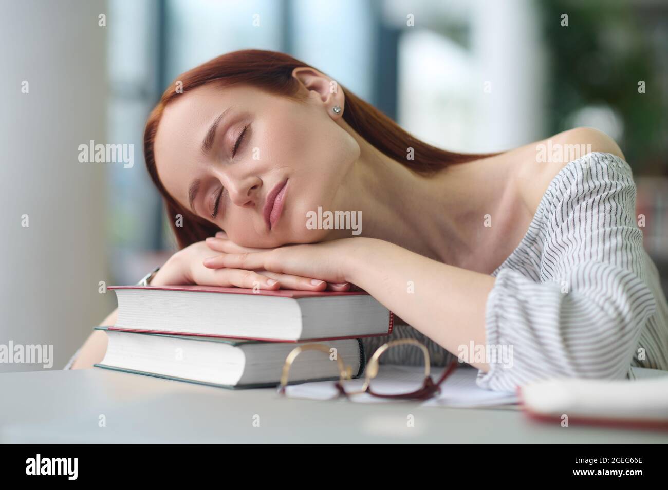 Overworked researcher napping at a public library Stock Photo - Alamy