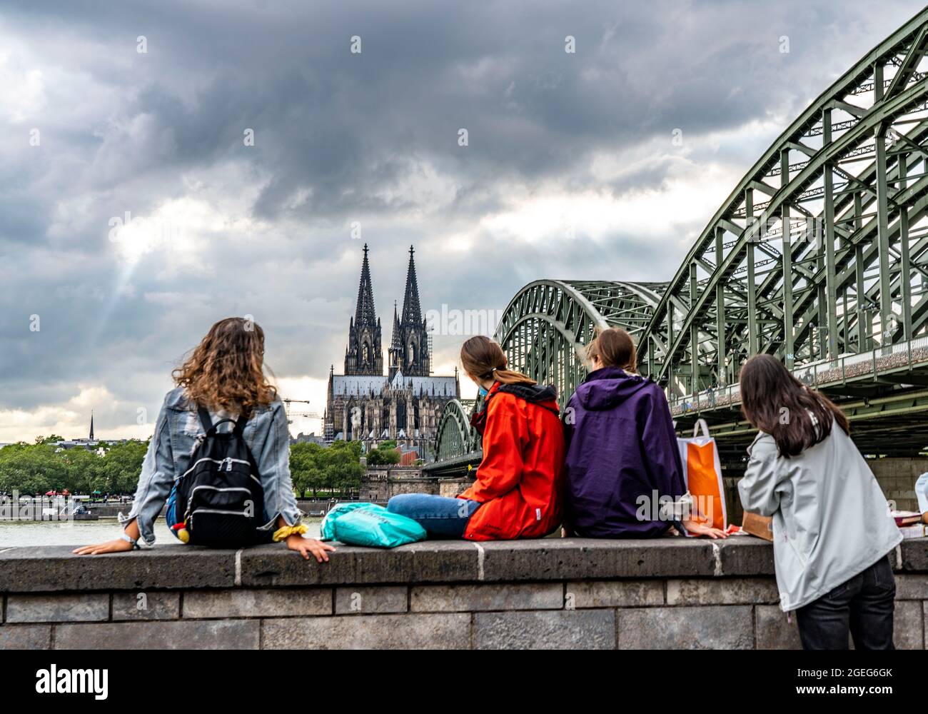 Cologne Cathedral, Hohenzollern Bridge, people on the Rhine promenade ...