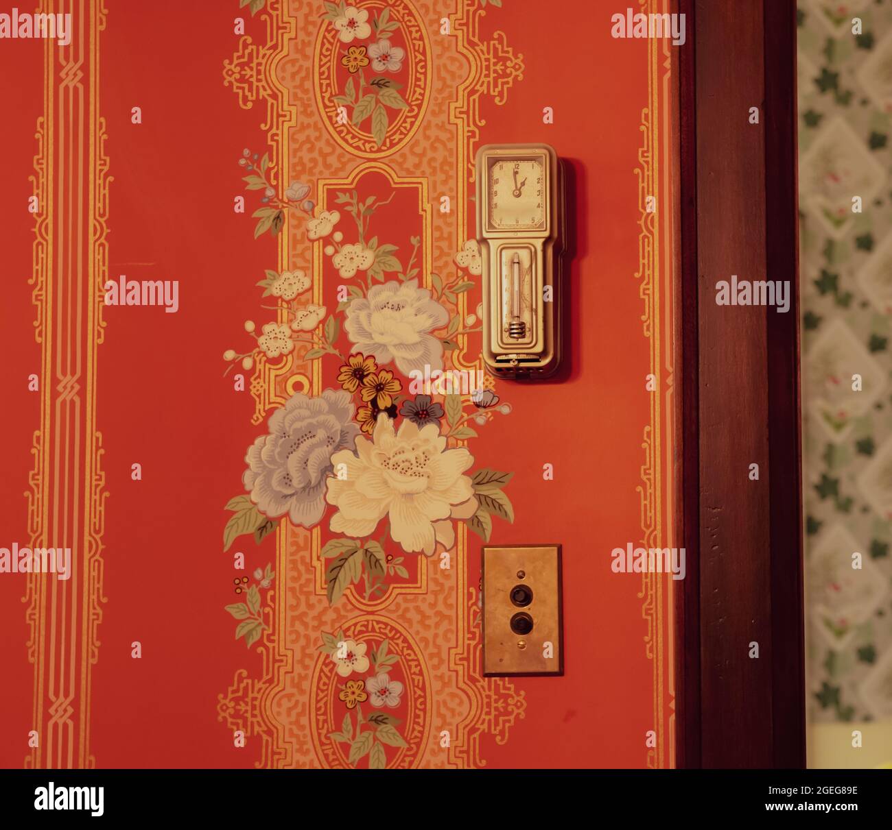 Old vintage clock on a red painted wall with flowers Stock Photo - Alamy