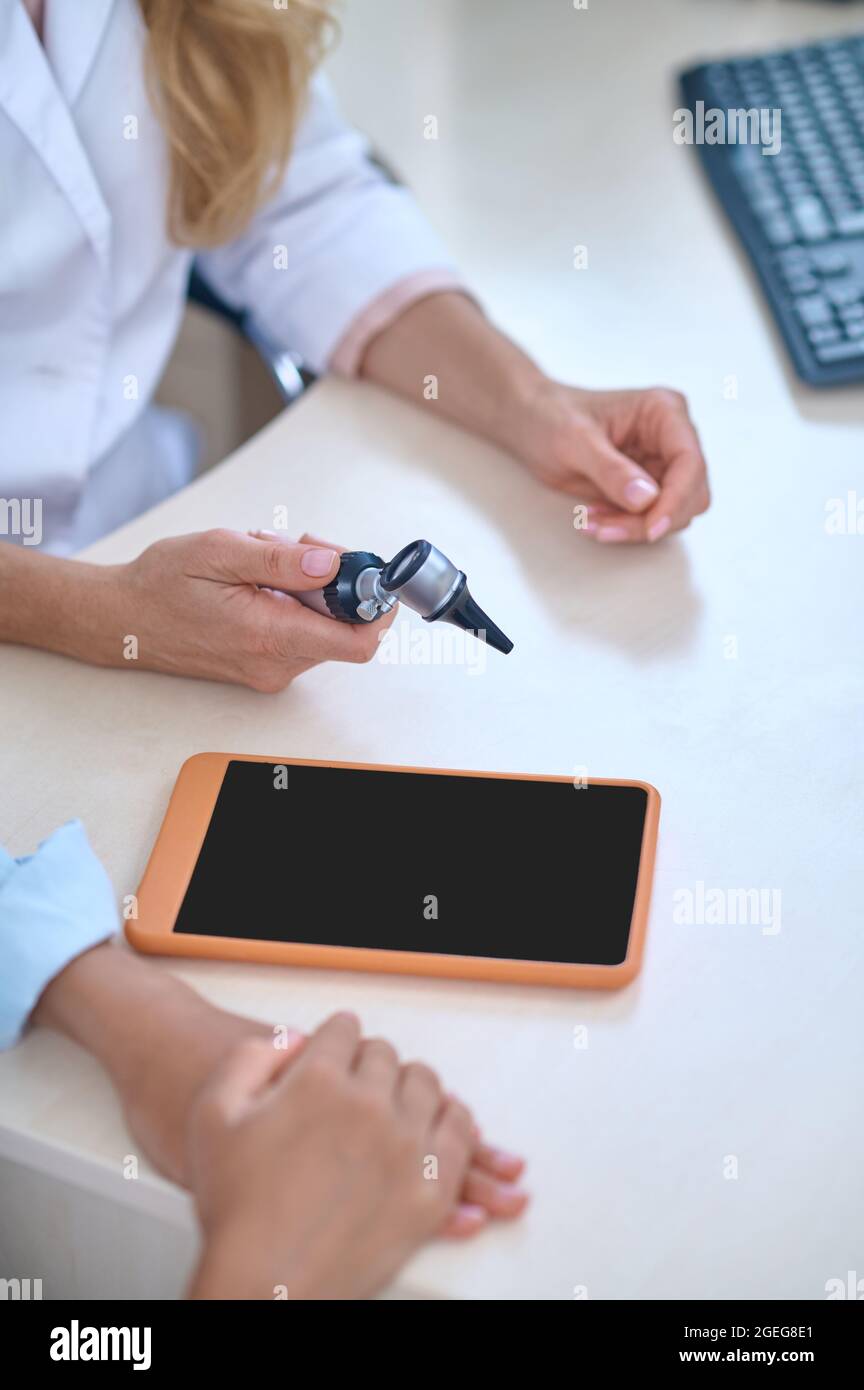 Hands of doctor otolaryngologist sitting at table Stock Photo