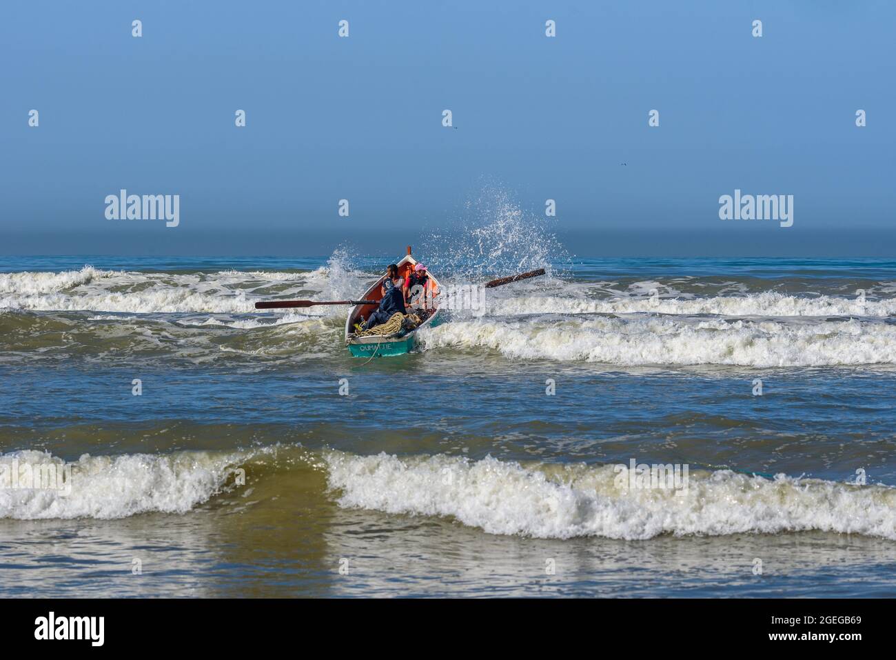 Rowing the net out, beyond the breakers in wide loup. Stock Photo