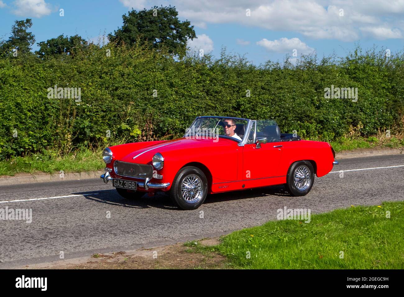 A front view of a Red MG Midget 1500 Petrol convertible roof down vintage classic car retro driver vehicle automobile Stock Photo