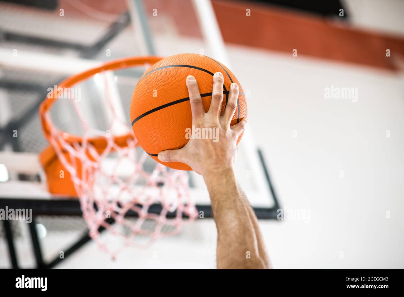Sportman throwing a ball into the basket Stock Photo