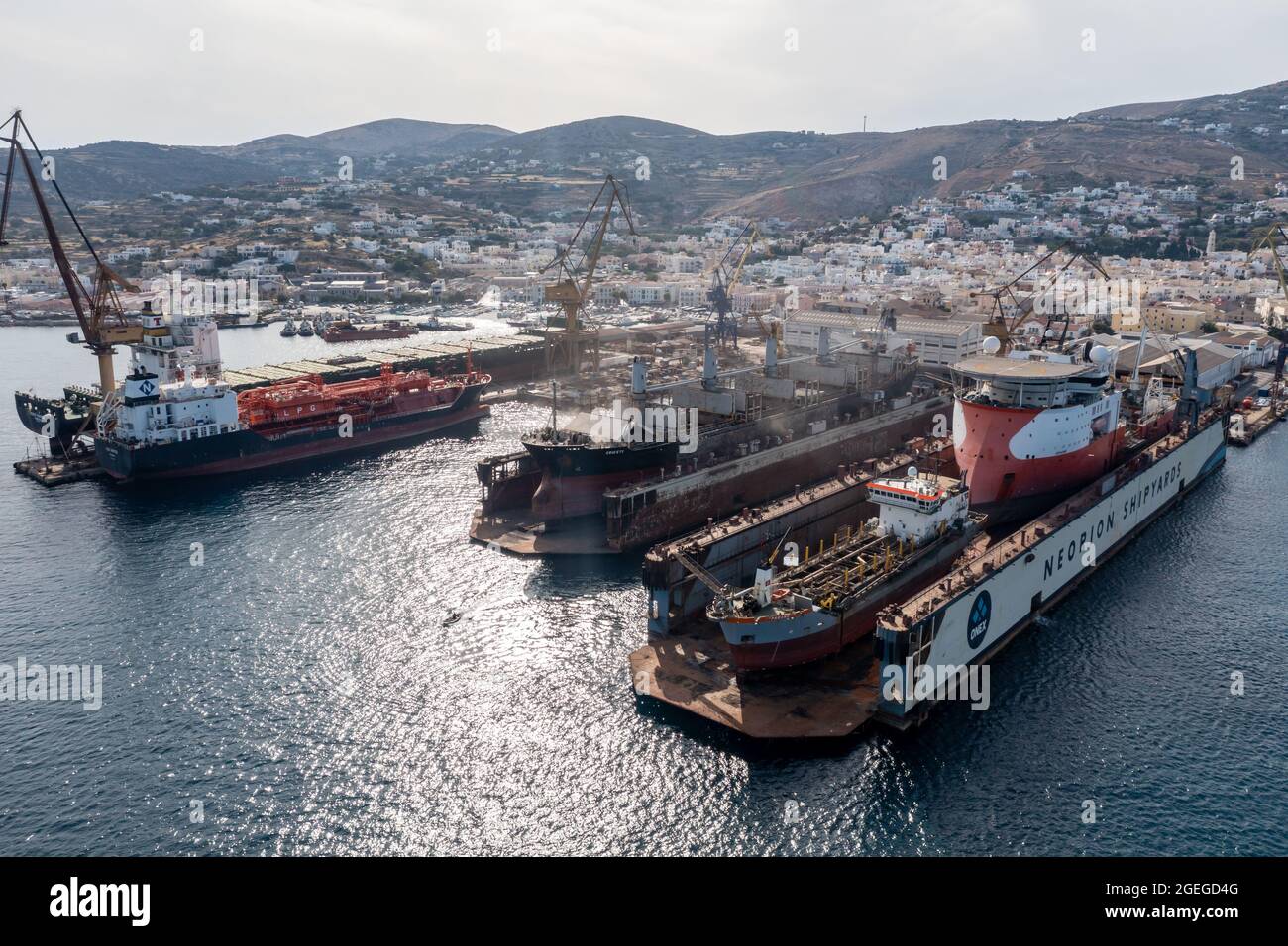 Syros island, Cyclades, Greece. May 26, 2021. Neorion shipyard harbour and industrial plant at Ermoupolis capital of Siros. Ships, cranes, internation Stock Photo