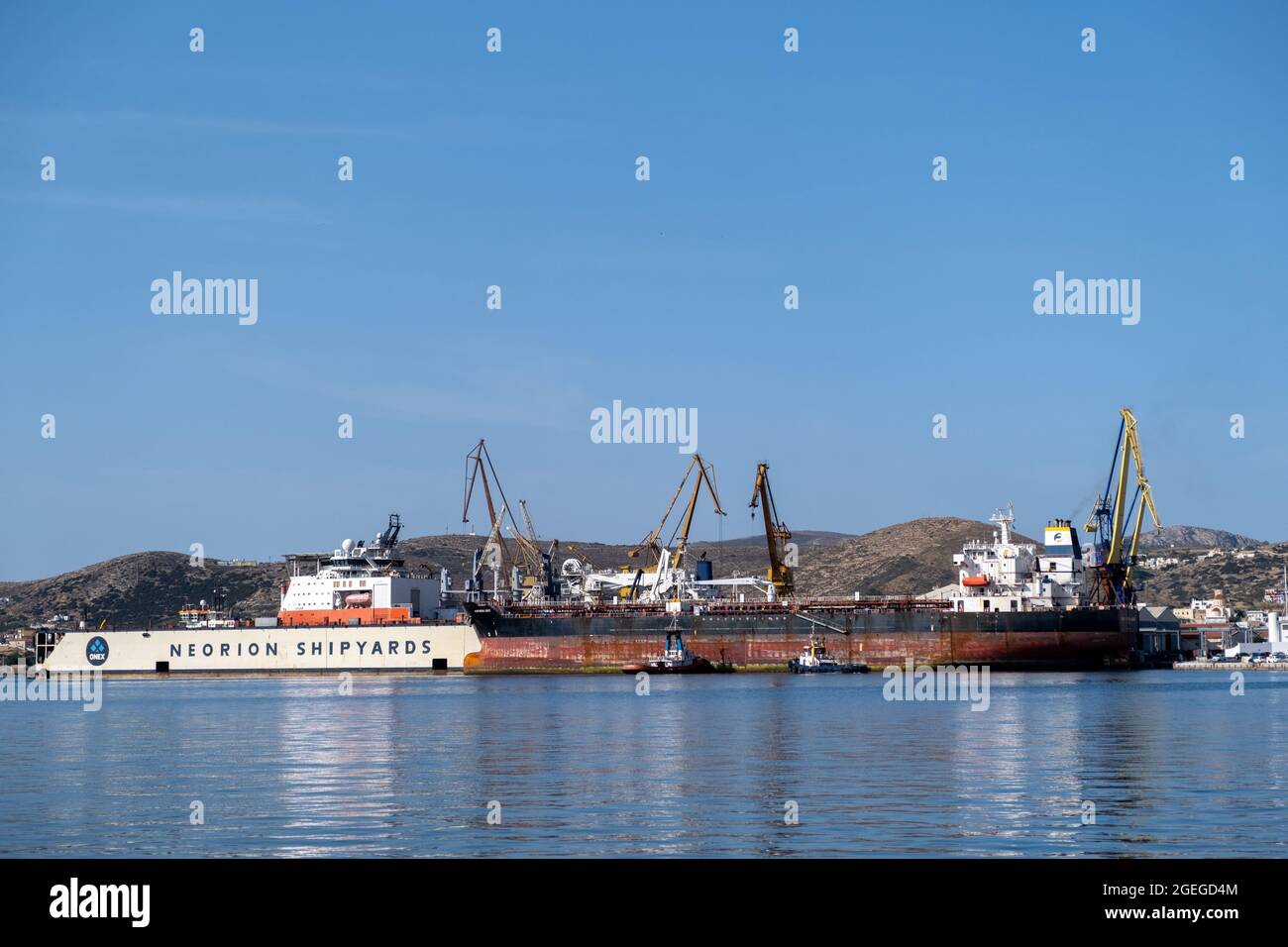 Syros island, Cyclades, Greece. May 27, 2021. Neorion shipyard harbour and industrial plant at Ermoupolis capital of Siros or Syra town. Ships, cranes Stock Photo