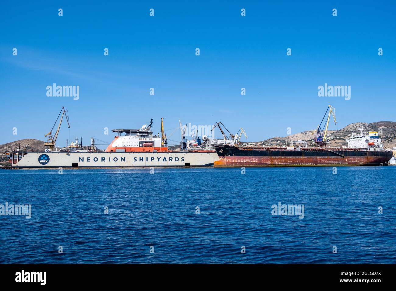 Syros island, Cyclades, Greece. May 27, 2021. Neorion shipyard harbour and industrial plant at Ermoupolis capital of Siros or Syra town. Ships, cranes Stock Photo