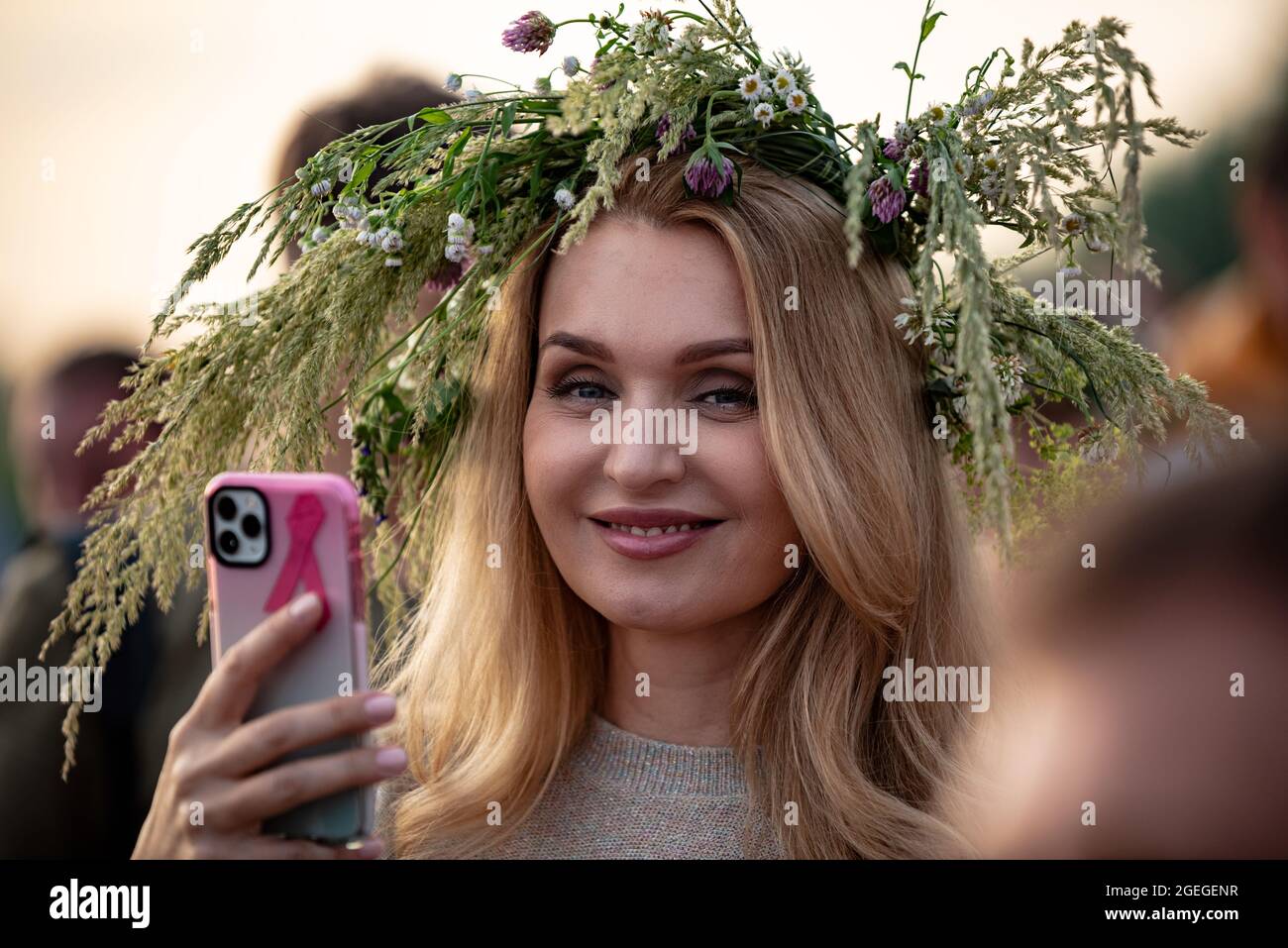 Warsaw, Poland, June 2021: People celebrate the Kupala Night, traditional Slavic holiday. Portrait of a happy woman wearing flower head wreath. Midsum Stock Photo
