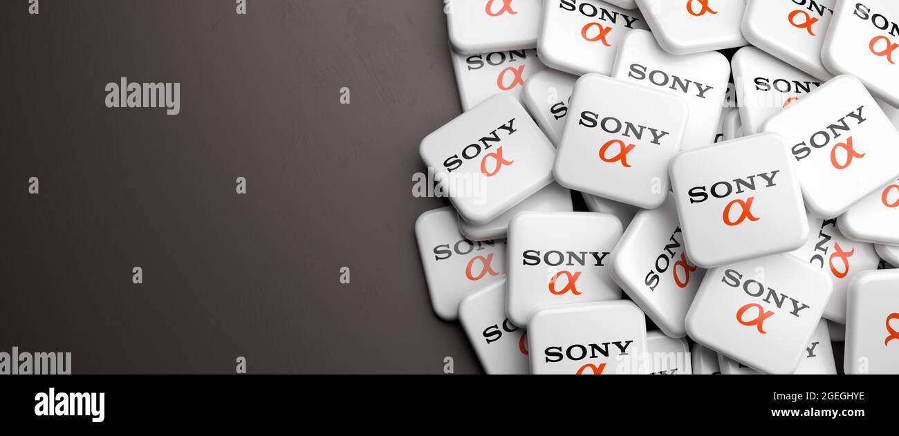 Logos of the Japanese camera system Sony Alpha on a heap on a table. Copy space. Web banner format. Stock Photo